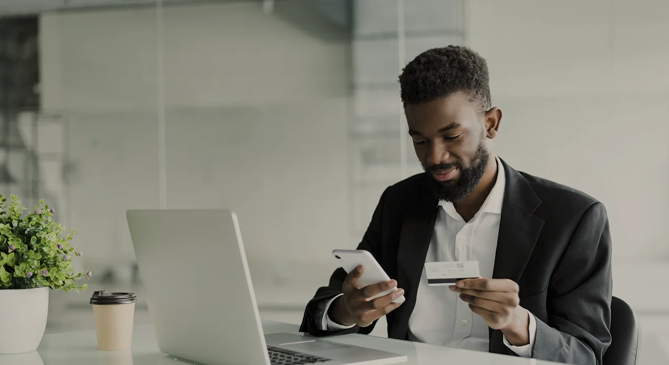 Open Finance - Homem com cartão de crédito comprando pelo celular